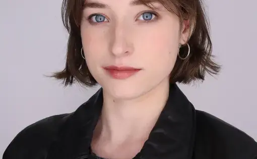 Headshot of Alyson wearing a leather jacket and grey shirt