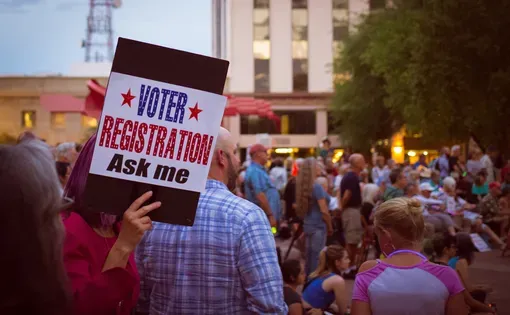 Sign reads "VOTER REGISTRATION Ask me." United States. Image by Johnny Silvercloud/Shutterstock.