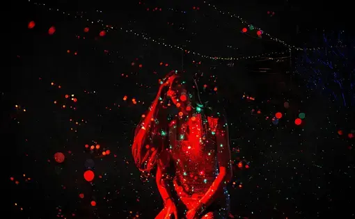 Drag queen in red light against black background