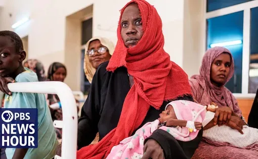 A Sudanese woman carries a baby
