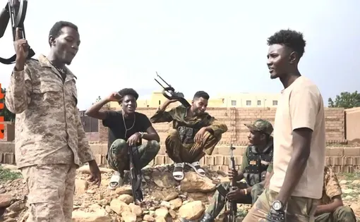 Young men hold guns in Sudan