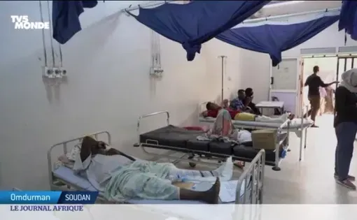 Patients lay in beds in a hospital ward.