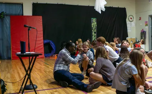 Man speaking with young students.