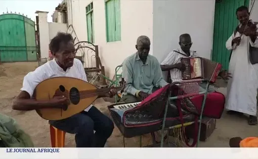 A group of four old men sit outside on a driveway to play piano, string instruments.