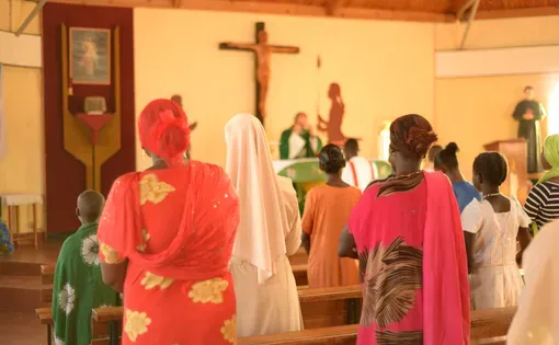 Korr, Marsabit county, Kenya - October 2017. Roman catholic mass in a local church. Women are praying during the mass celebration. Missionaries in Africa. Image by Adriana Mahdalova/Shutterstock.