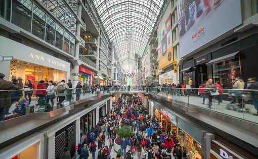 A crowded shopping mall is decorated for the holiday season