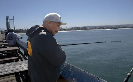 Imperial Beach resident and fisherman Jorge Arrollo looks over the water as he casts his line over the local pier on April 2, 2024. He says that the water quality has significantly decimated fish populations in Imperial Beach.