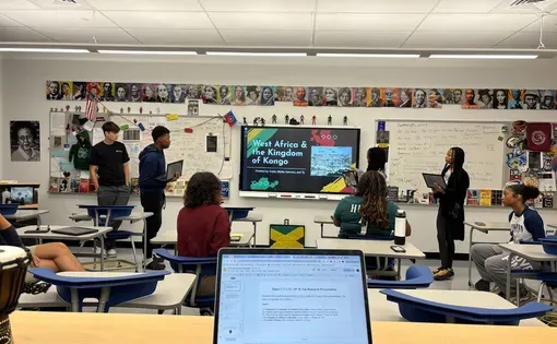 Students in an AP African American Studies class present a unit project on West Africa and Kingdom of Kongo to classmates seated at desks.