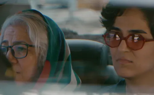 Two women sit in the back of a car, Iran