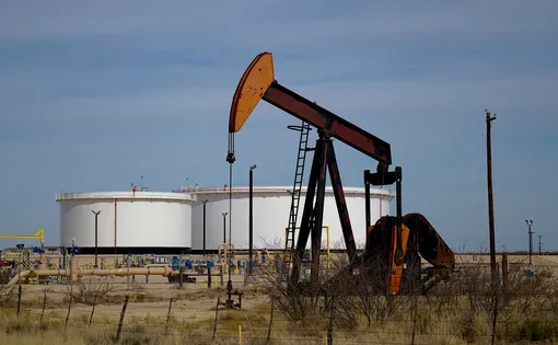 Pumping unit and tank batteries in the Permian Basin. Image courtesy of Sean Hannon acritelyphoto/Shutterstock.