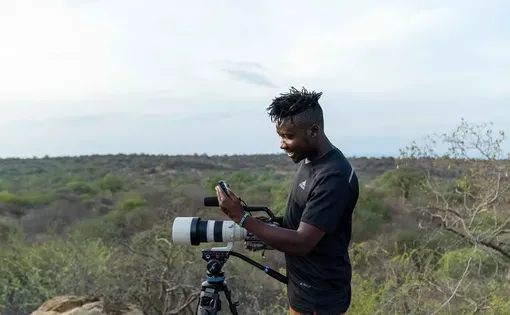 Side profile of a photographer and his equipment in an outdoor setting
