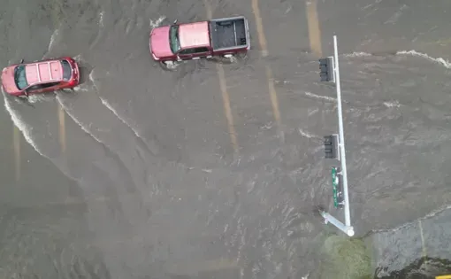 aerial view of cars driving through heavy flooding