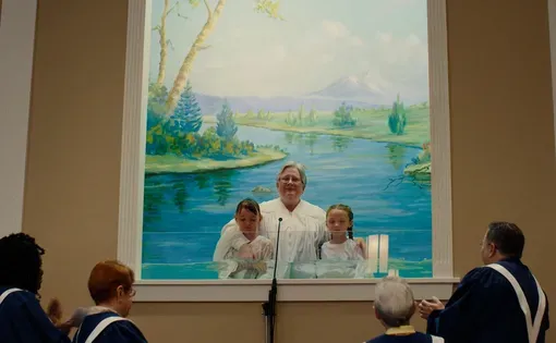 a pastor and two children after being baptized in a church