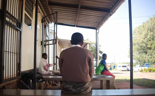 A child sits outside a building.