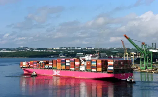 Halifax, Canada - July 30, 2022: Tugboats assist the One Hangzhou Bay container ship as it leaves the Fairview Cove Container Terminal in the Bedford Basin in Nova Scotia, Canada.
