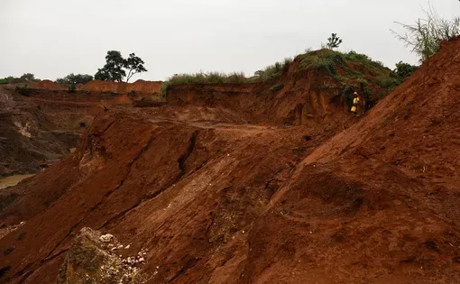 Una mujer observando una mina a cielo abierto de cobre y manganeso a pequeña escala en Serenje, en la Provincia Central de Zambia. Fotgrafía de Kang-Chun Cheng.
