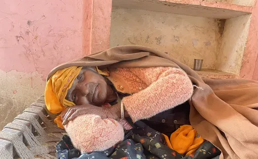 An elderly woman lies on a floor