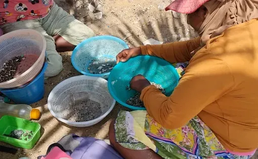 Woman bending over some buckets