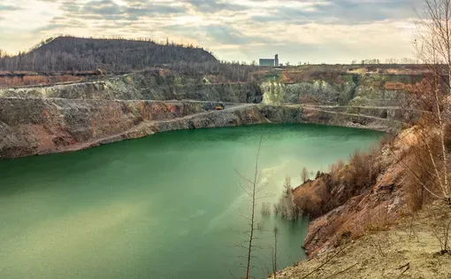 Open pit mining in Ukraine. Granite quarry with a lake in Kremenchuk city. Surface mining - soil and rock overlying the mineral deposit (the overburden) are removed
