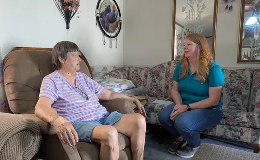Deborah Nagy (left) and Marsha Craiger chat inside Nagy's home in Wise. Craiger administers Senior Cool Care, a state energy assistance program that serves people who are over 60 who experience poverty.