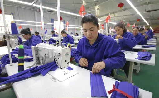 HOTAN, CHINA - APRIL 27 2019. Uigur women work in a cloth factory in Hotan county, Xinjiang province, China.