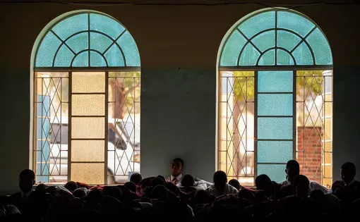 Students pray in front of windows