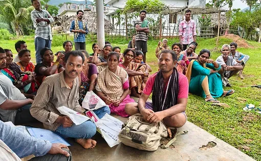 A group of people sit on a field