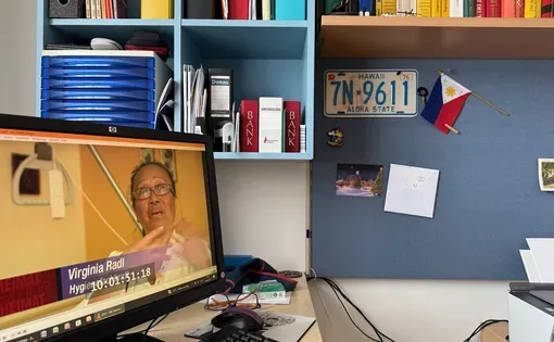 In her home office, Virginia Radl, president of the Philippine Nurses Association-Austria, revisits a television interview highlighting the contributions of Filipino nurses to Austria’s healthcare system.