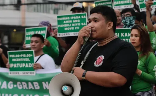 John Jay Chan of National Union of Food Delivery Riders speaks at a protest rally against Grab’s fare restructuring in October 2023 in Quezon City. Image by Bernard Testa. Philippines.