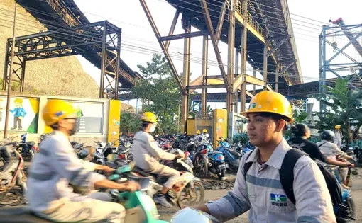 Indonesian workers commute under the conveyor belts of a coal-fired power plant supplying the nearby industrial sites in Morowali.