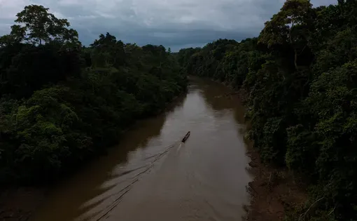a small canoe floats down the river