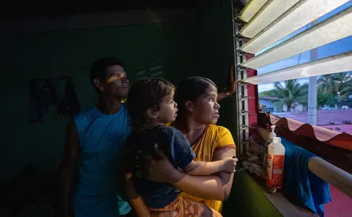 A woman holds her baby as she looks out