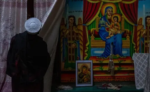 A monk reveals religious artwork inside the Abba Garima church.