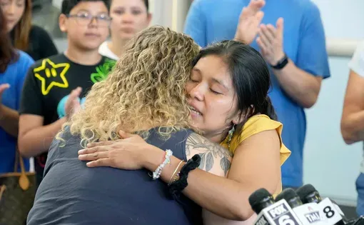 Two women hug.