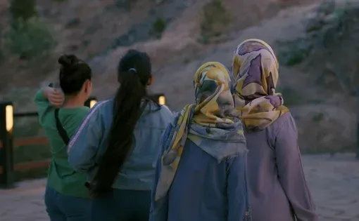Still from 'A Move' documentary shows four women with their backs turned, two wearing hijabs and two not