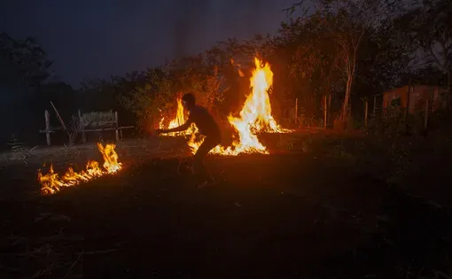 Morador usa fogo controlado em quintal na vila do Teotônio, comunidade formada após a submersão da antiga cachoeira pelo reservatório da Usina Hidrelétrica Santo Antônio, no rio Madeira. A região abriga antigas áreas de Terras Pretas de Índio. Foto: Maurício de Paiva/InfoAmazonia