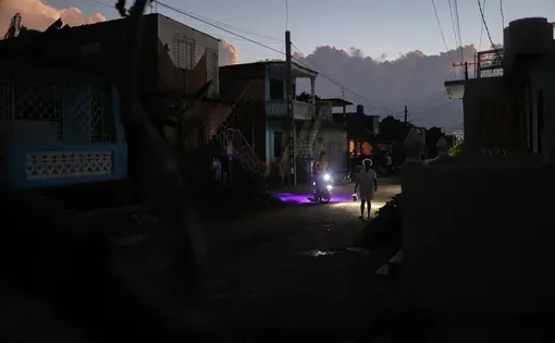 In a suburb on the outskirts of the city of Camaguey, people rush home after sunset. Photo : Luis Bustamante