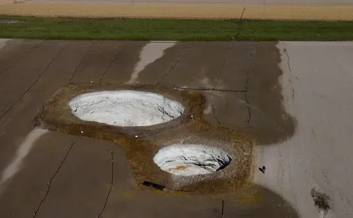 Two massive sinkholes on a field