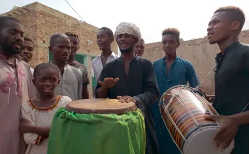 Sheedi musicians warm up the African drum and South Asian dhol during the Sheedi Mela on July 10, 2025, in Badin, Pakistan. Image by Manahil Naveed. Pakistan, 2025.