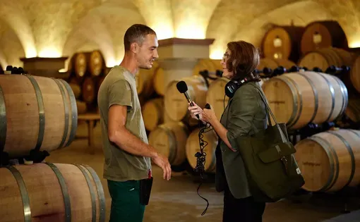 Deborah Becker talking to Lorenzo Leporoni in San Patrignano's winery. Image by Wilson Santinelli/WBUR.
