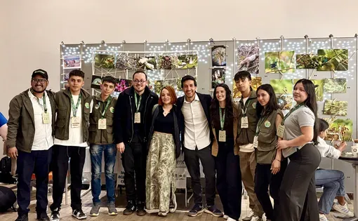 Personal del Pulitzer Center y jóvenes líderes ambientales posan frente a la muestra fotográfica de proyectos territoriales