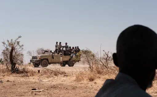 Members of the Rapid Support Forces drive in a converted pick up truck fitted with a machine gun In Tongoli this February. Photography by Guy Peterson