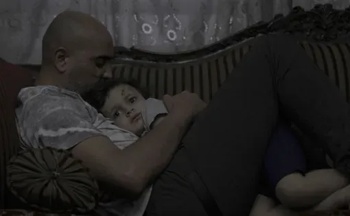 Man and his son, hugging on a couch