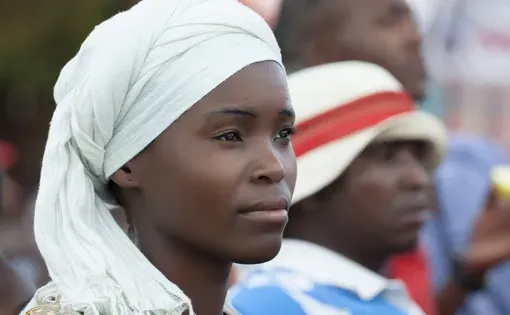 A young woman wears a white head scarf
