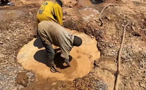 Maru, Zamfara. Two children wash gold-bearing soil in a shallow pool. Image by Abdullah Tijani.