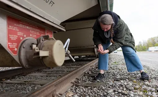 Sherri Mason, a Gannon University researcher, picks up plastic pellets, pieces barely larger than a grain of rice, that litter the ground where they are transferred from rail cars to trucks and delivered to local manufacturers on May 1, 2026, in Erie, Pennsylvania. (Brian Cassella/Chicago Tribune)