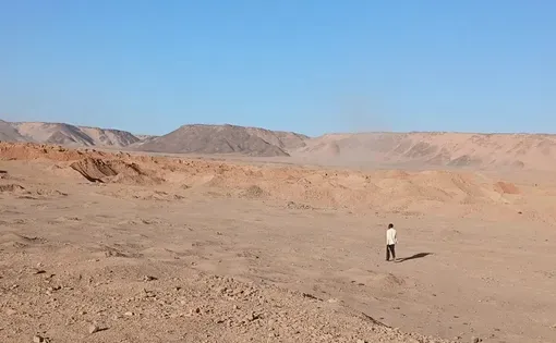 Djado, Niger. A man walks toward excavated pits at a mining site. Photo: Amma Moussa.