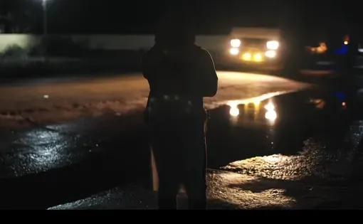 A woman on a darkened street