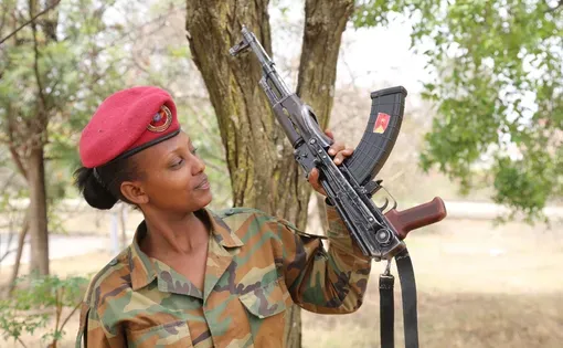 Female Tigray Defense Forces (TDF) fighter in camouflage uniform and red beret holding an automatic rifle. Mekelle, Tigray - ‎June ‎29, ‎2022