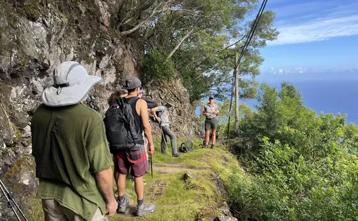 Sister Alicia Damien Lau, one of the Sisters of Saint Francis who lives in Kalaupapa, speaks with visitors outside the Kalaupapa Bookstore during the new National Park Service hiking tour July 9. Image by Mia Anzalone. United States.